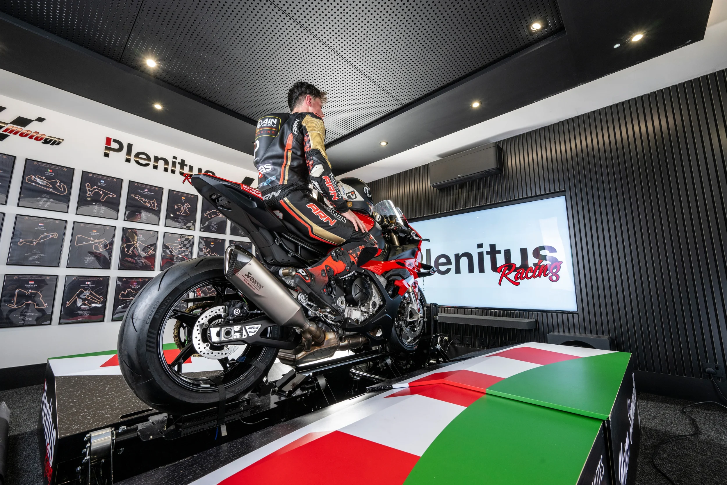 Professional rider training on the Plenitus Racing Sim inside the circuit analysis room