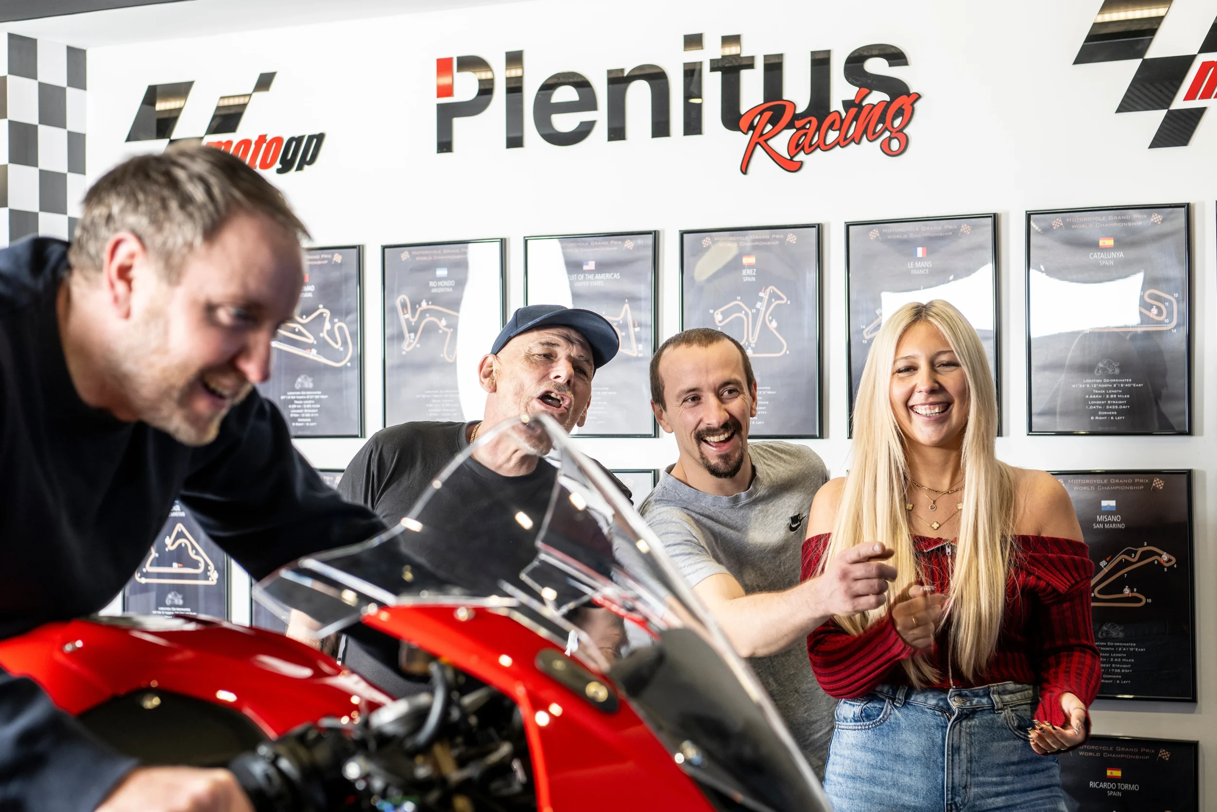 Group enjoying the Plenitus Racing Sim experience with a motorcycle on display