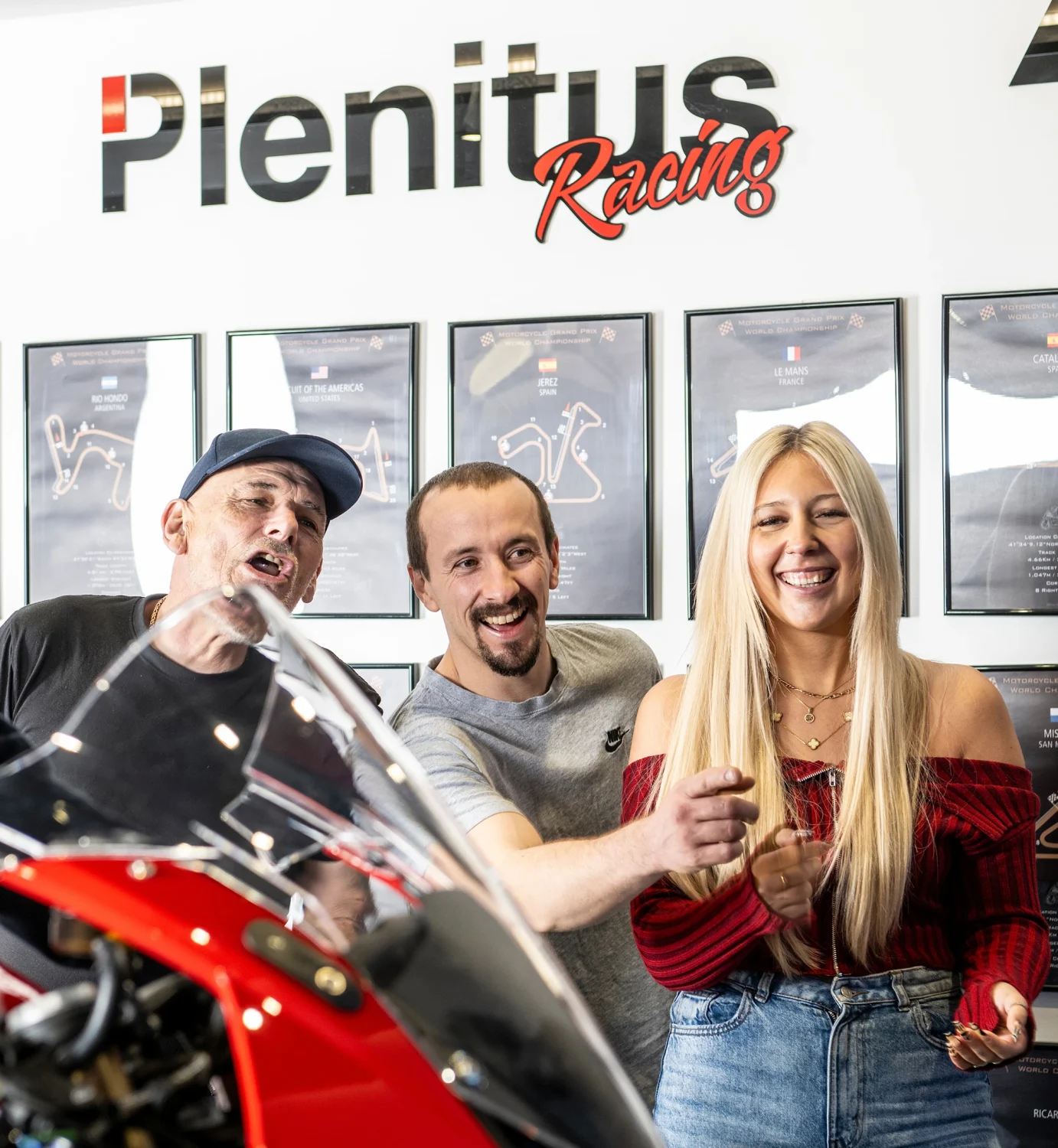 Group enjoying the Plenitus Racing Sim experience with a motorcycle on display