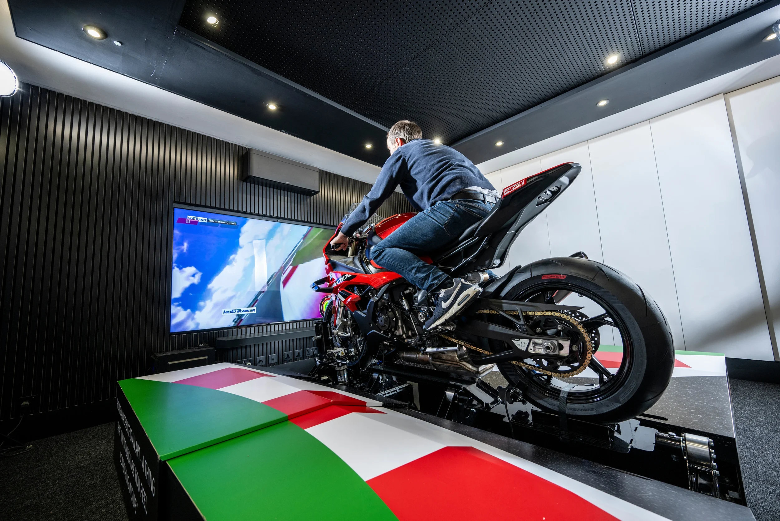 Rider training on the Plenitus Racing Sim while practicing on a virtual circuit